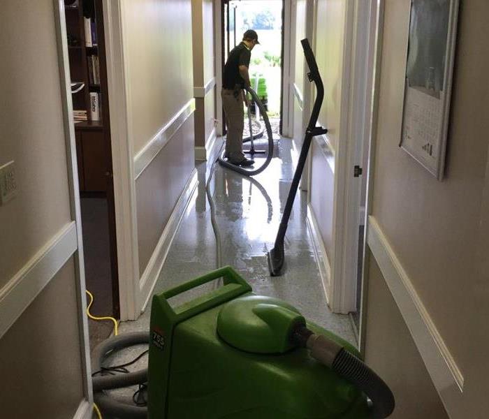 hallway with water on ground, technician is extracting water