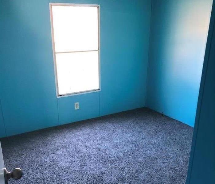 same room with repaired walls, floor, ceiling, new carpet and paint