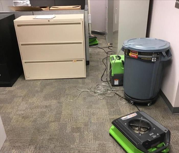 SERVPRO fans and a dehumidifier set up in office space with wet carpet