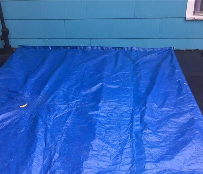 blue tarp covering portion of a roof